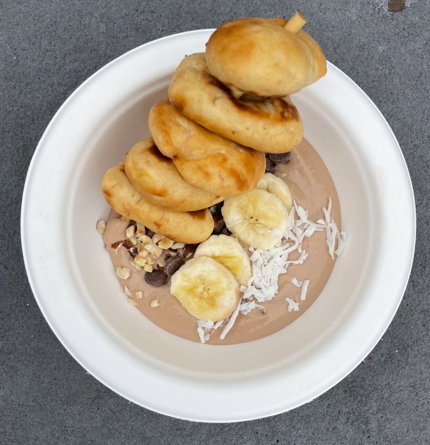 Bowl of dessert hummus garnished with banana slices, chocolate chips, and coconut