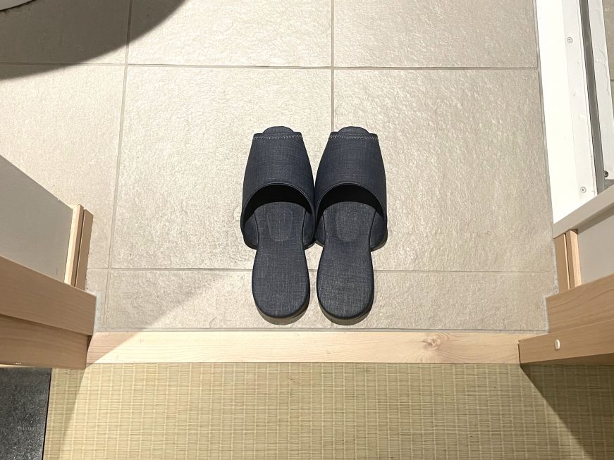 Pair of dark blue slippers on a bathroom floor