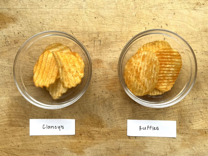 Two small glass bowls with a few potato chips in each 