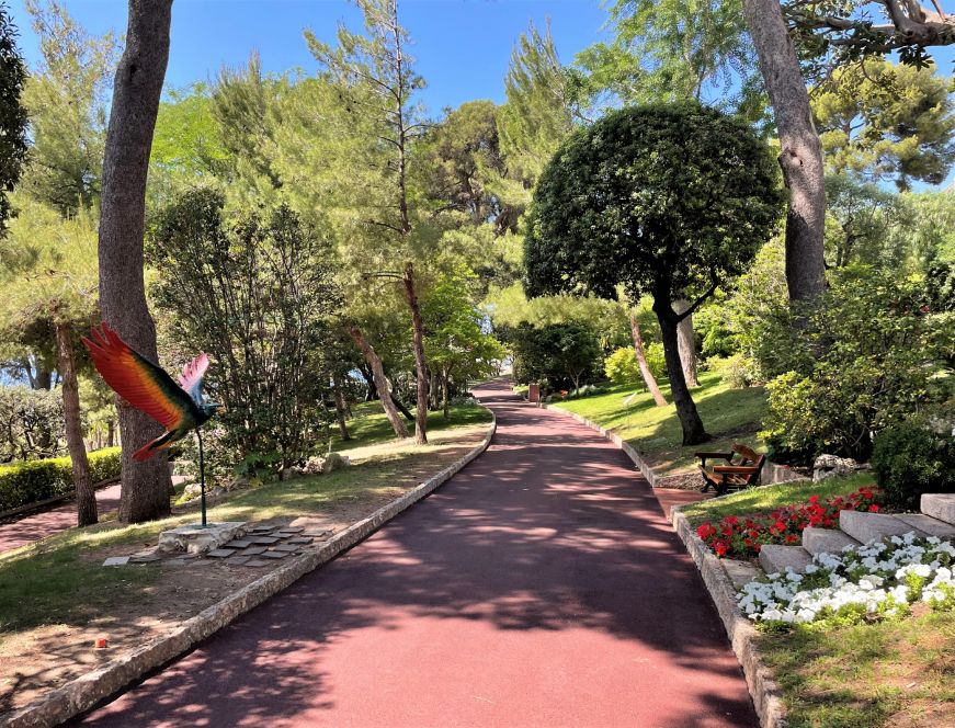 Garden with large trees, modern sculptures, and a curving path