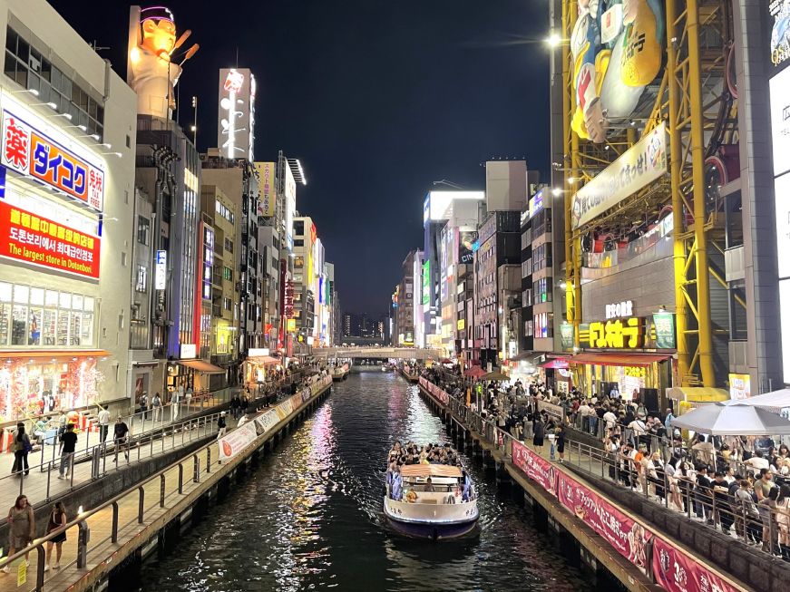 Canal with large buildings lit with neon lights on either side