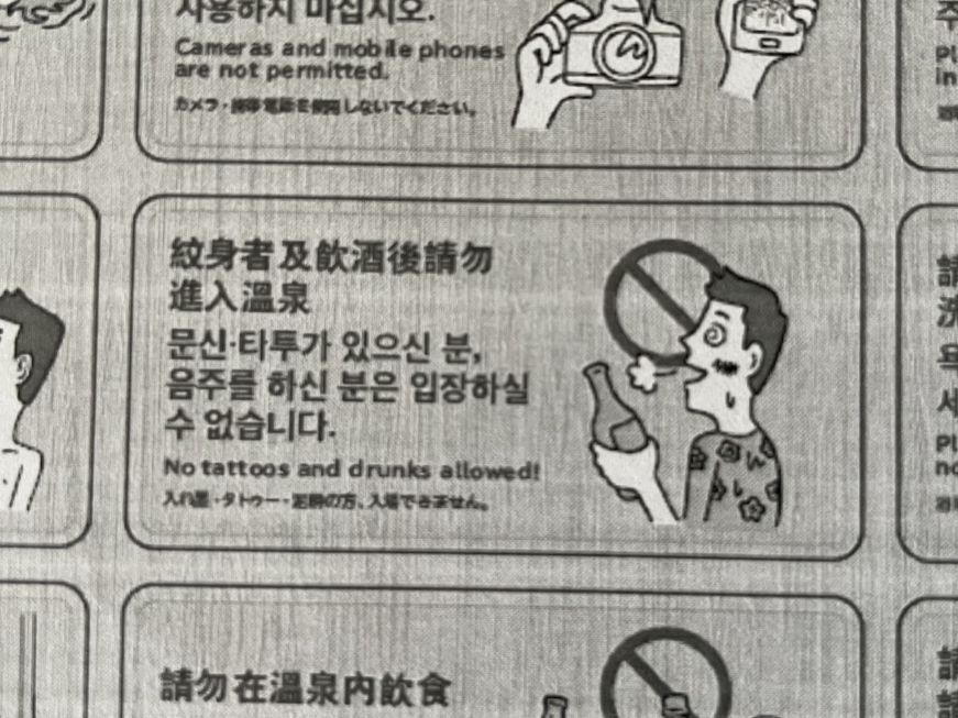 Cartoon of tattooed man with a bottle of beer and text reading "No tattoos and drunks allowed!"