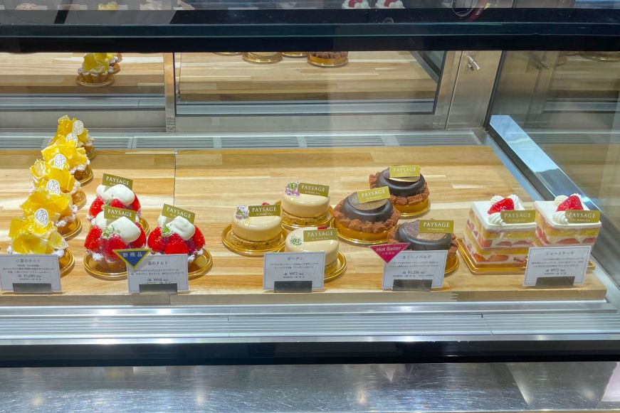 Glass case filled with elaborate cakes and desserts