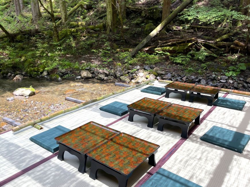 Platform over a river with low tables and cushions