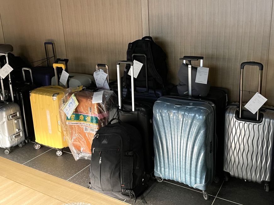 Assortment of suitcases in a hotel lobby, each with a luggage shipping tag