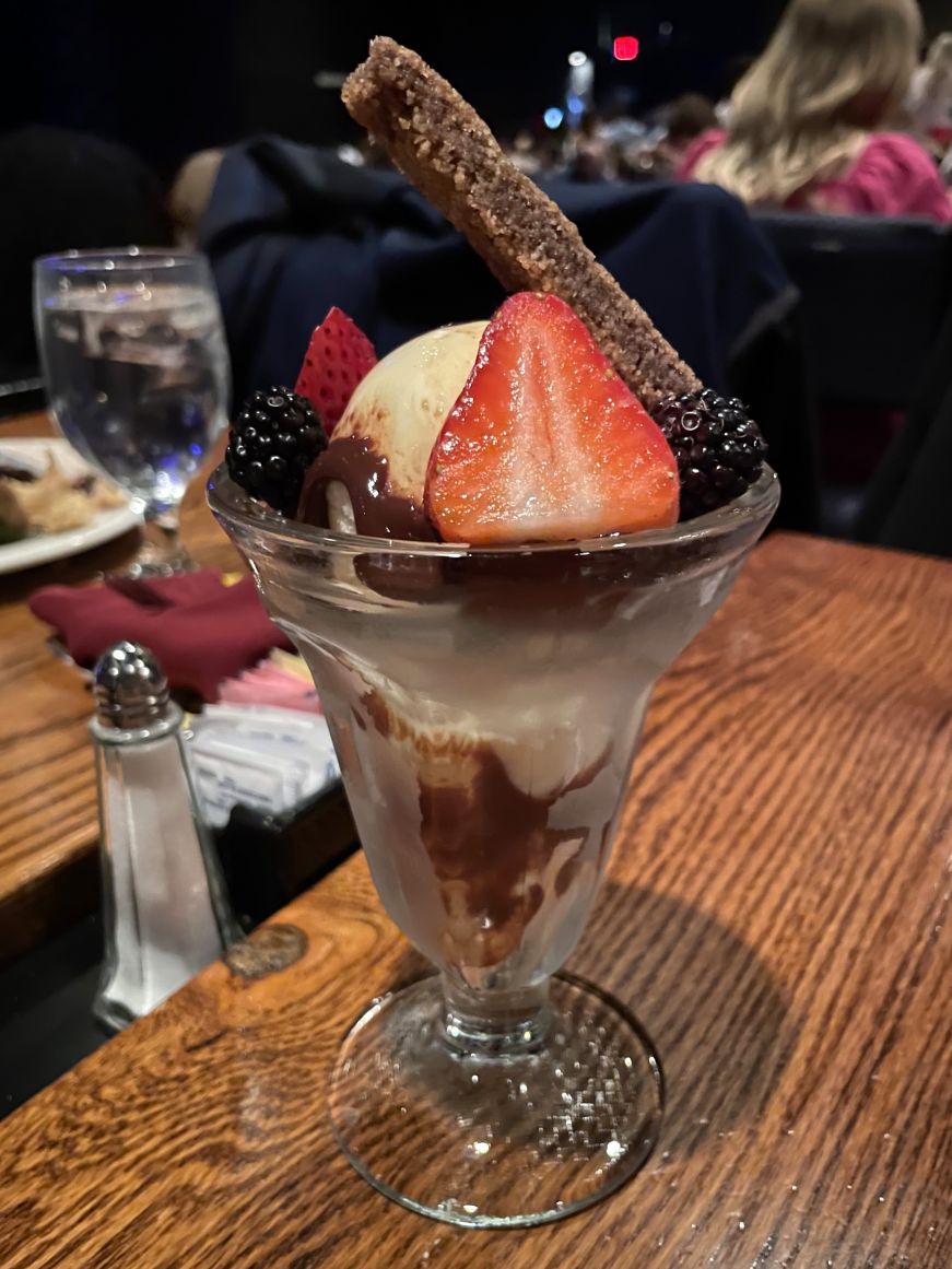 Tulip dish with vanilla ice cream, fudge, strawberries, blackberries, and a rectangular cinnamon cookie