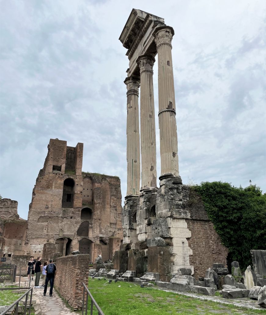 Three columns surrounded by building ruins