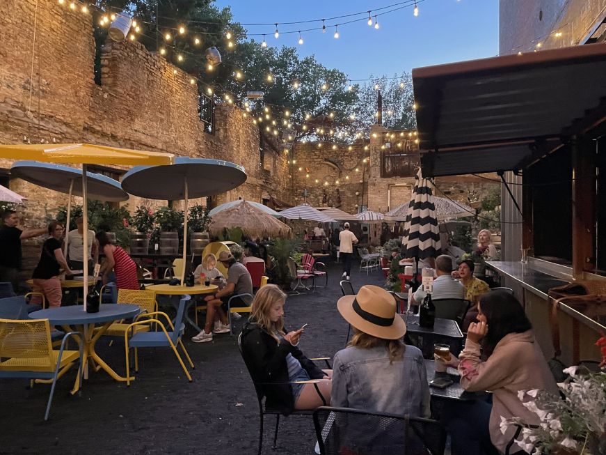 Patio surrounded with partial brick walls and decorated with garden furniture and fairy lights