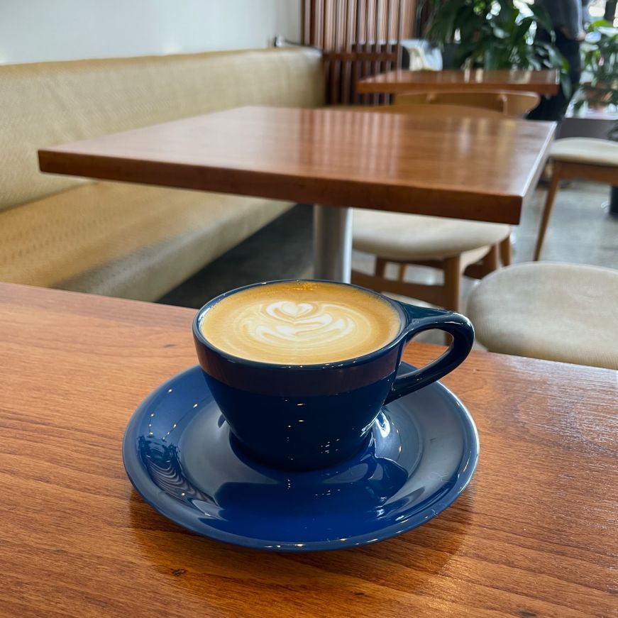 Cappuccino on a table with plants in the background