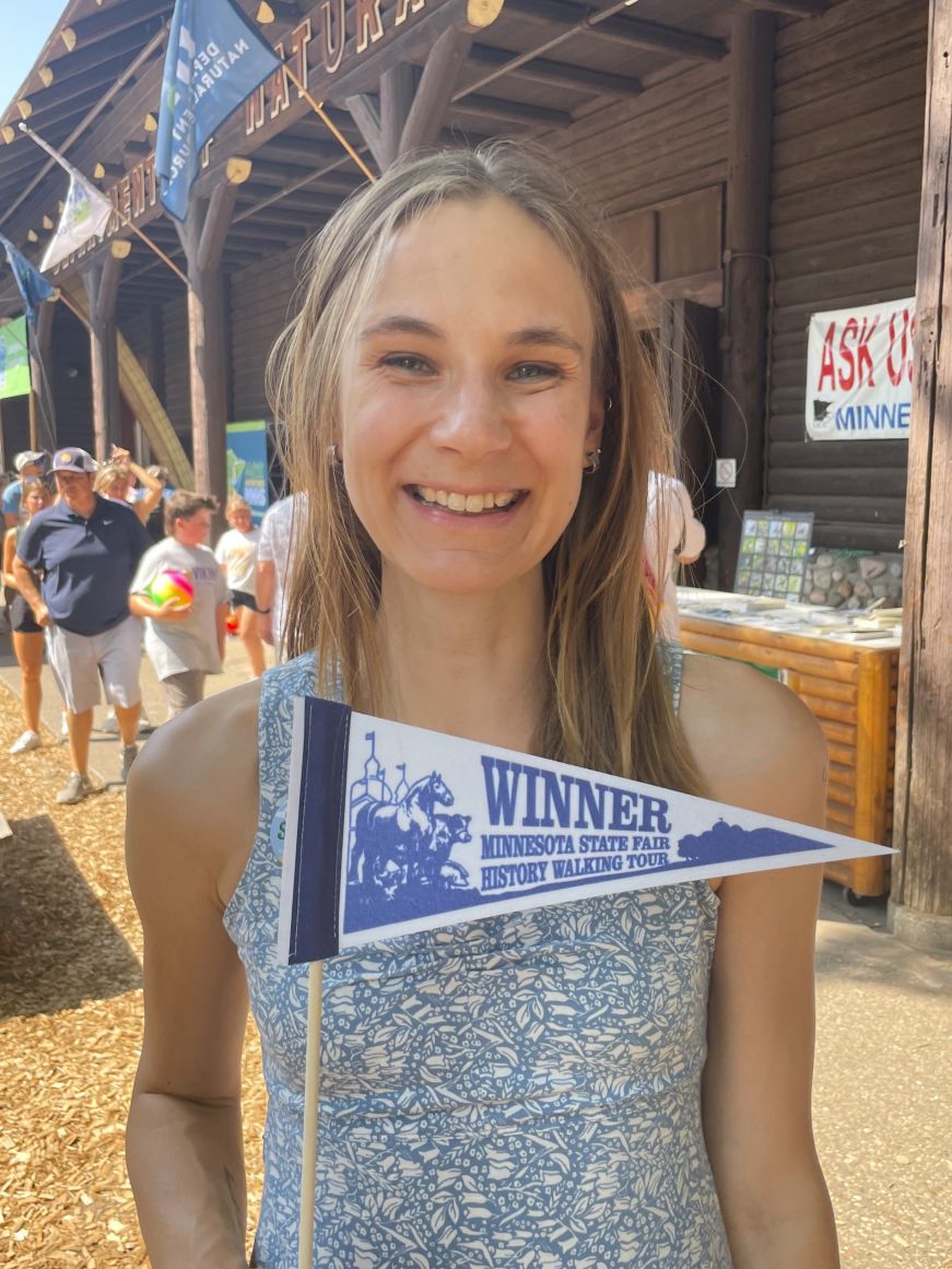 Stacy holding a walking tour pennant