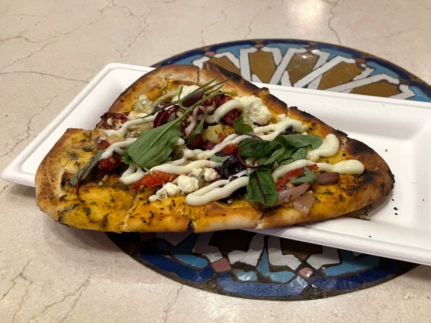 Flatbread topped with artichokes, roasted vegetables, olives, and feta