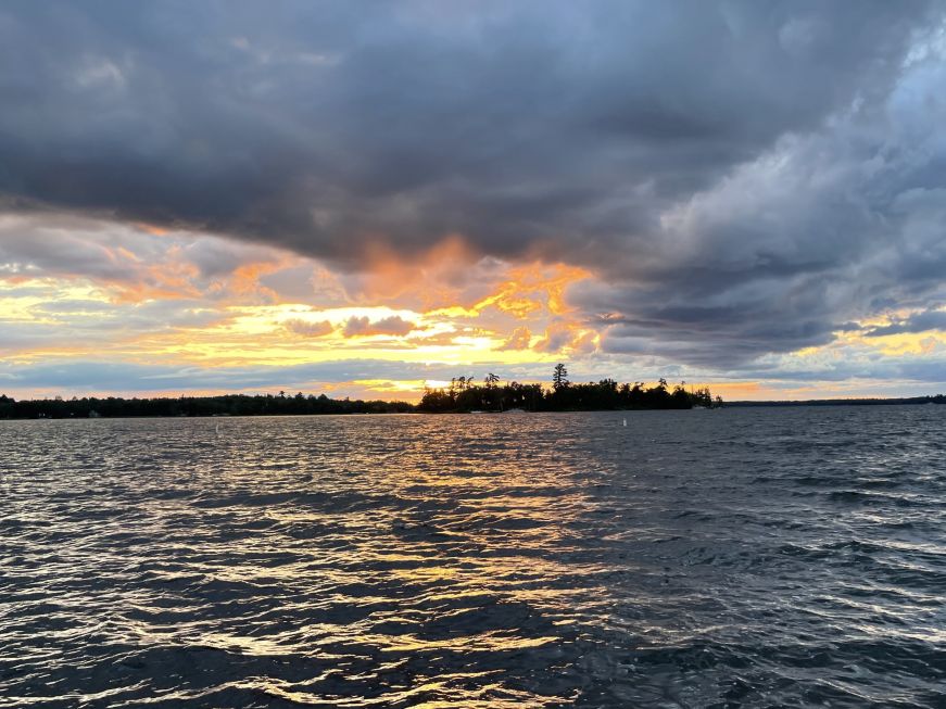 Sunset over an island with pine trees on a large lake