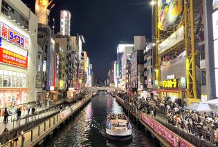 Boat in a canal with neon-lit buildings on either side