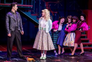 Man in leather jacket and woman in full skirt on a stage